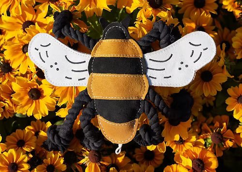 Detailed overhead shot of the Bessie the Bumble Bee toy by Aurora Paws, highlighting the wings and black and yellow suede body stitching, supplied by Paw Branch.