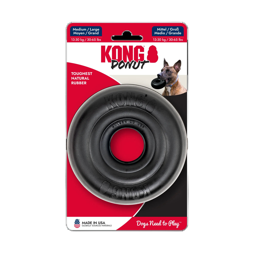 Kong Donut dog toy in its original retail packaging, featuring a large black rubber toy with a red center on a red and white card backing with a dog photo.